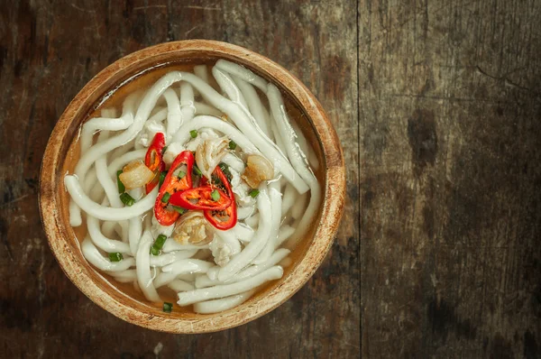 Close-up de macarrão udon em tigela de madeira no fundo do chão de madeira — Fotografia de Stock