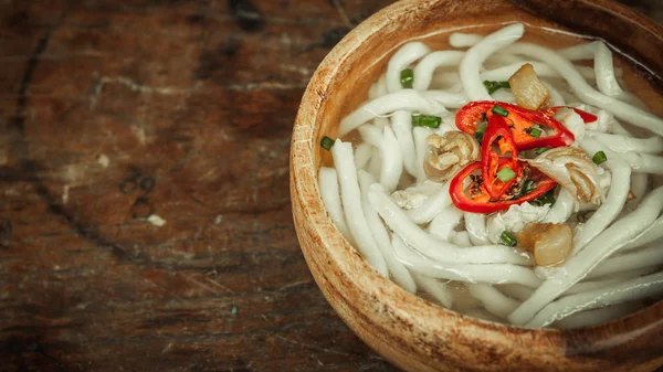 Primo piano di udon tagliatella in ciotola di legno su fondo pavimento in legno — Foto Stock