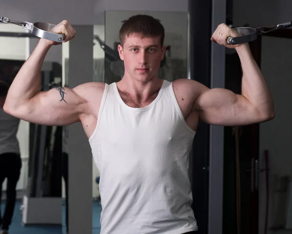Hombre deportivo muscular en el gimnasio — Foto de Stock