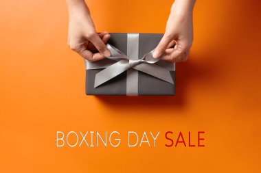 Boks günü indirimi, genç bir kadın eli ve hediye kutusu alıcısı.