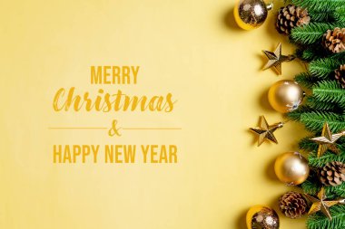 Noel balosu ve çam ağacı. Sarı arka planda Noel süslemesi var.