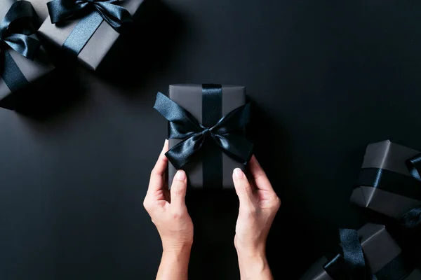 节礼日营销理念 女性手拿着黑色背景的礼品盒 — 图库照片