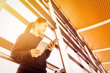 Modern terminalde uçuş beklerken Asya 'lı kadın cep telefonu kullanıyor