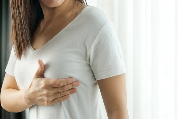 여성은 가슴에 있는지 손으로 확인하며 유방암의 징후를 — 스톡 사진