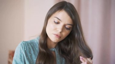 Kafasından vurulmuş, bin yıllık melez bir kadının aynaya bakıp saçlarını taramasını çekmiş. Sinirli genç bir kız. Hasarlı saçtan memnun değil. Tarzı zor, sabah rutini..