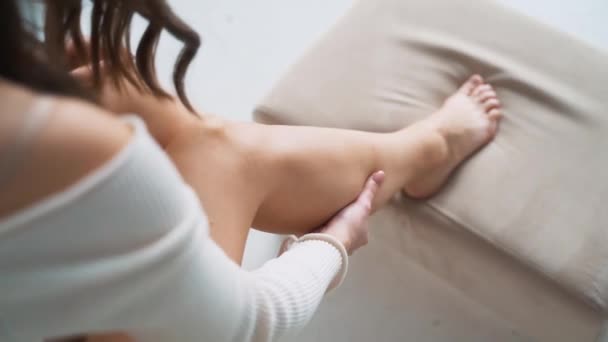 Kvinnan lider av smärta i benen. gnida benet och vristen mot arbetssjukdomar. Åderbråck. — Stockvideo