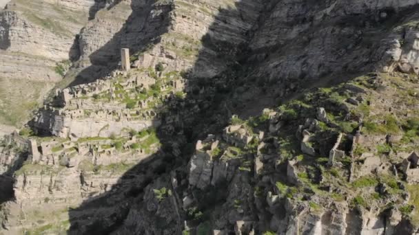 Vista aérea del pueblo muerto en la cima de la montaña. Edificios antiguos, ruinas de piedra de la antigua ciudad. Increíble pueblo abandonado único. Casas de piedra del pueblo abandonado Daguestán — Vídeo de stock