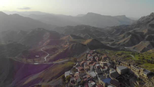 Aerial view of of the village aul in Dagestan. There are many old houses with colorful roofs on the top of the mountain. Incredible view of the huge mountains. Ancient settlement of the Caucasus — Stock Video