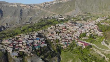Dağıstan 'daki köyün havadan görünüşü. Dağın tepesinde renkli çatıları olan birçok eski ev var. Devasa dağların manzarası inanılmaz. Kafkasların antik yerleşim yeri