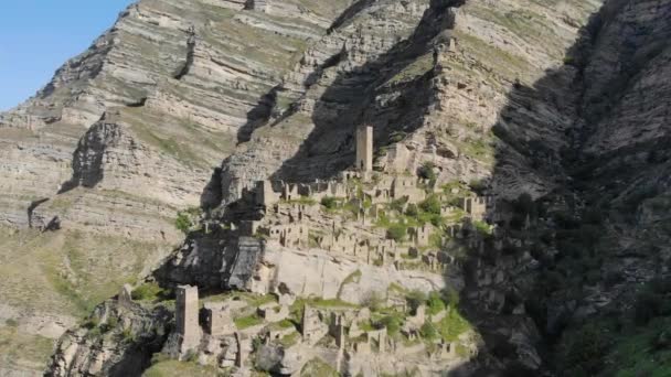 Pemandangan udara desa mati di puncak gunung. Bangunan kuno, reruntuhan batu kota kuno. Desa terbengkalai yang menakjubkan. Rumah batu dari desa terlantar Dagestan — Stok Video