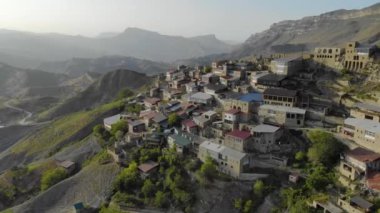 Dağıstan 'daki köyün havadan görünüşü. Dağın tepesinde renkli çatıları olan birçok eski ev var. Devasa dağların manzarası inanılmaz. Kafkasların antik yerleşim yeri
