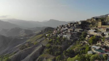 Dağıstan 'daki köyün havadan görünüşü. Dağın tepesinde renkli çatıları olan birçok eski ev var. Devasa dağların manzarası inanılmaz. Kafkasların antik yerleşim yeri