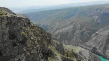 Dünyanın en derin kanyonlarından biri olan Sulak Kanyonu 'nun havadan görünüşü. Bir dağ vadisinde derin, dolambaçlı bir turkuaz nehri. Kafkasya manzaraları. Uçurumlar, tepeler ve dağlar. Rus Doğası
