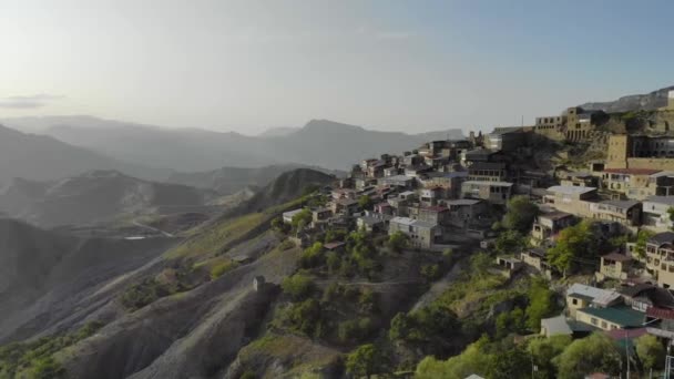 Вид з повітря на село в Дагестані. На вершині гори є багато старих будинків з барвистими дахами. Неймовірний вигляд величезних гір. Стародавнє поселення на Кавказі — стокове відео