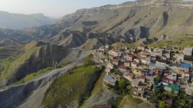 Dağıstan 'daki köyün havadan görünüşü. Dağın tepesinde renkli çatıları olan birçok eski ev var. Devasa dağların manzarası inanılmaz. Kafkasların antik yerleşim yeri