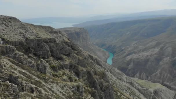 Letecký pohled na Sulak Canyon, který je jedním z nejhlubších kaňonů na světě. Hluboká, klikatá tyrkysová řeka v horském údolí. Kavkazská krajina. Útesy, kopce a hory. Ruská příroda — Stock video