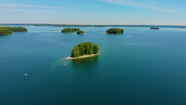 Vista aérea do lago azul profundo Uvildy, Ural do Sul, Rússia. Grupo de pequena ilha verde no lago contra o pano de fundo de altas montanhas. Verdura brilhante exuberante e sol quente de verão — Vídeo de Stock