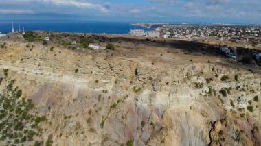 Kayalara çarpan dalgaların havadan görüntüsü. Karadeniz 'in mavi dalgalarının en üst görüntüsü. Dağın tepesindeki kırmızı araba. Gemi su üzerinde yelken açar. Kayalar denizden görülebilir.