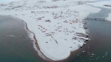 Barents Sea Bay, Atlantik Okyanusu, Murmansk 'ın hava manzarası. Mavi deniz, evlerin bulunduğu kıyılarda beyaz dalgalara ayrılıyor. Fırtına. Zemin karla kaplı. Kış. Turizm
