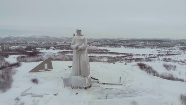 Letecký pohled na památník Aljoša, Murmansk. Vysoký pomník zobrazuje vojáka v helmě, plášti a se zbraní. Winter. Památník neznámého vojáka a jeho výkon. Místo kulturního dědictví — Stock video