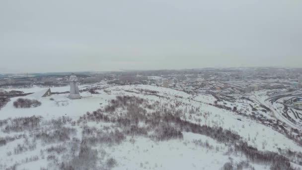 Flybilde av Alyosha Memorial, Murmansk. Det høye monumentet viser soldat i hjelm, frakk og våpen. Vinter. Monument over den ukjente soldaten og hans bragd. Kulturminner – stockvideo