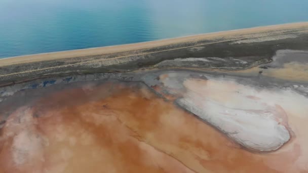 Pemandangan udara dari danau garam krem. Danau adalah cermin. Air danau mencerminkan langit biru dan awan yang mengambang. Danau dan laut dipisahkan oleh sebuah bar pasir. Laut biru tenang terlihat — Stok Video