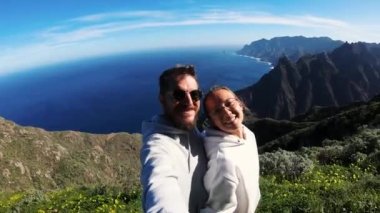 Birbirine aşık çiftler tepeye tırmanıp kendilerini vurdular. Okyanus kayalara çarpar. Dağlar gökyüzüne ve parlak güneşe karşı karanlık görünür. Rüzgarda dalgalanan yoğun yeşiller. Yürüyüş. Balayı