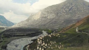 Ölülerin şehri, Kuzey Osetya 'nın havadan görünüşü. Alanlı cenazeler Kafkasya 'daki tepede bulunur. Mahzenler arasındaki yollar. Beyaz evler ve karanlık çatılar şeklinde ayinsel yapılar. Tarihsel nekropolis