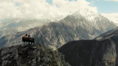 Çift dağın tepesinde, Kafkasya 'da oturuyor. Kafkas dağlarına tepeden bakan bir dağ sırasının kenarında duruyor. Dağların karlı zirveleri. Bulutlar yukarıdan sarkıyor. Korkunç güzellik.