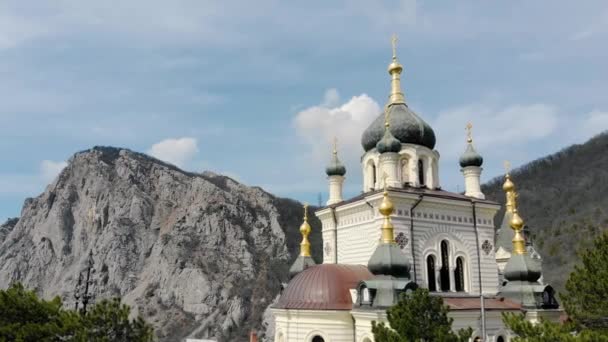 山の上にフォロス教会,フォロス,クリミア半島.深い緑に覆われた山の上に緑のドームで雪の上に白い教会を飛ぶ。黒海の崖の上のキリスト教会 — ストック動画