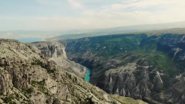 A Sulak Canyon légi kilátása, ami az egyik legmélyebb kanyon a világon. Egy mély, kanyargós türkiz folyó egy hegyi völgyben. Kaukázusi tájak. Sziklák, dombok és hegyek. Orosz természet — Stock videók