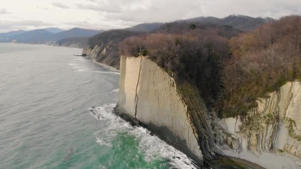 Αεροφωτογραφία του βράχου Kiseleva, περιοχή Krasnodar. Οι άνθρωποι στέκονται στην κορυφή του βράχου. Ο βράχος αποτελείται από λευκές πλάκες και στρώματα. Η καταιγίδα συναρπάζει τη γαλάζια θάλασσα. Μοναδικό τοπίο. Άνοιξη — Αρχείο Βίντεο