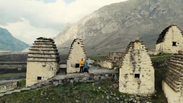 Αεροφωτογραφία της πόλης των νεκρών, Βόρεια Οσετία. Αλανιανές ταφές βρίσκονται στο λόφο του Καυκάσου. Μονοπάτια ανάμεσα σε κρύπτες. Τελετουργικές κατασκευές σε μορφή λευκών σπιτιών με σκούρες στέγες. Ιστορική νεκρόπολη — Αρχείο Βίντεο