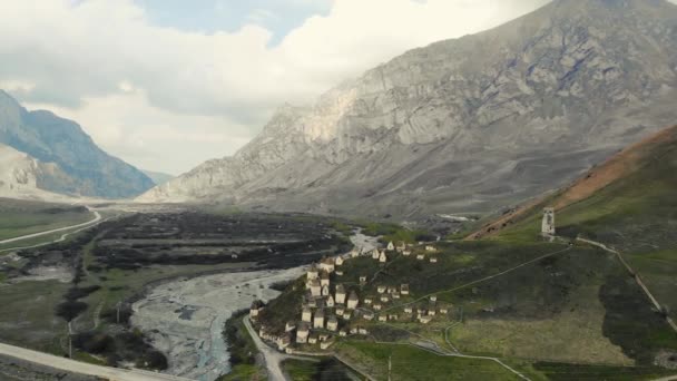 Vista aérea da cidade dos mortos, Ossétia do Norte. Enterros alanianos estão localizados na colina no Cáucaso. Caminhos entre criptas. Estruturas rituais em forma de casas brancas com telhados escuros. Necrópole histórica — Vídeo de Stock