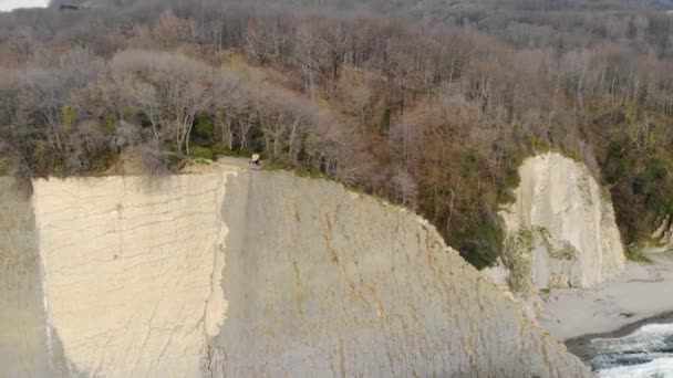 Luchtfoto van Kiseleva rots, Krasnodar Territory. Mensen staan op de klif. Rock bestaat uit witte platen en lagen. Storm prikkelt azuurblauwe zee. Uniek landschap. Voorjaar — Stockvideo