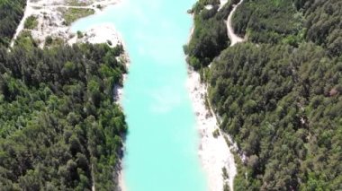 Yapay göl, kaolin açık çukur ve turkuaz su. Zümrüt yapay gölet. Beyaz kumlu kıyılar, parlak yeşillik ve göletin kenarlarındaki patikalar. Mavi gökyüzü beyaz bulutlu, güneşli
