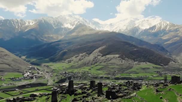 Aerial view of dead village on top of mountain. Ancient buildings, stone ruins of ancient city. Amazing view of mountains tops of which are covered with snow. Impressive mountain natural landscape — Stock Video