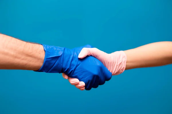 Mężczyzna Kobieta Ręka Rękawiczkach Spotykają Się Uścisku Dłoni Odizolowane Niebieskim — Zdjęcie stockowe