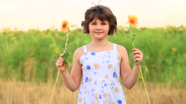Retrato feliz de menina no campo esconde olho com girassol — Vídeo de Stock