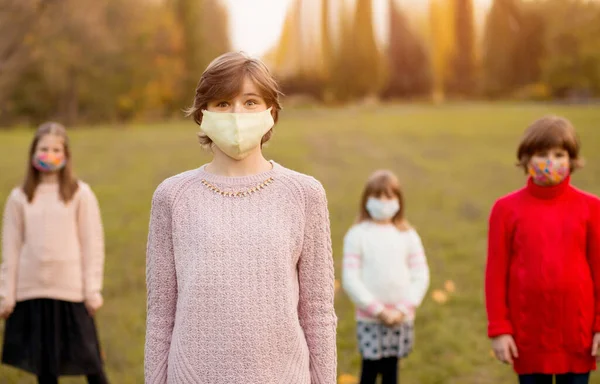 Multidão de crianças andando em máscaras médicas protetoras na rua durante a epidemia de coronavírus. Novo conceito de estilo de vida de crianças com rostos cobertos. Foco seletivo — Fotografia de Stock