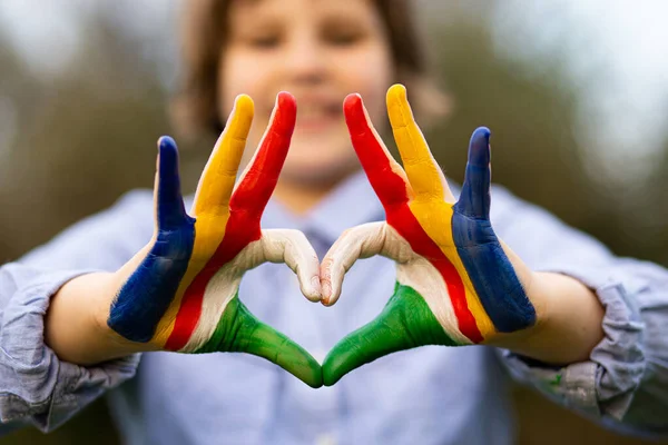 Las manos de niño pintadas en color de la bandera de Seychelles muestran el símbolo del corazón y el gesto de amor —  Fotos de Stock