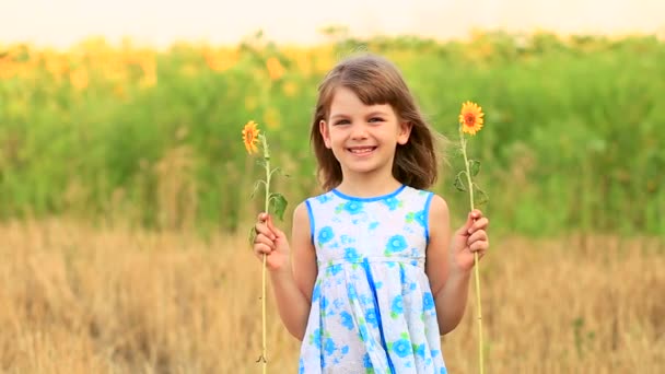 Retrato feliz de menina no campo esconde olho com girassol — Vídeo de Stock