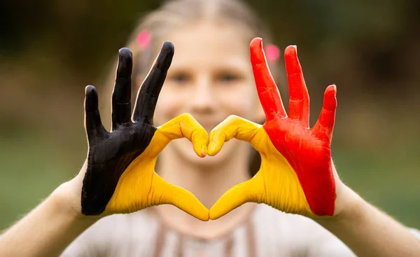 Manos de niño pintadas en Bélgica bandera color mostrar símbolo de corazón y el gesto de amor —  Fotos de Stock