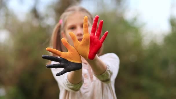 Retrato feliz da menina com as mãos pintadas nas cores da bandeira da Bélgica — Vídeo de Stock