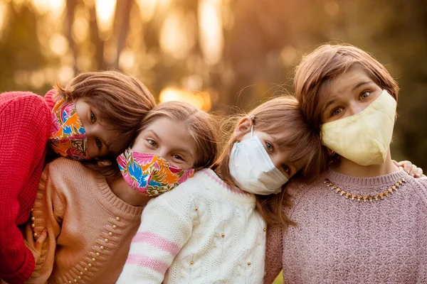 Sekelompok gadis usia empat sekolah mengenakan topeng pelindung menunggu berakhirnya pandemi penguncian dan kembali ke gaya hidup normal — Stok Foto