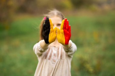 Child girl show hands painted in Belgium flag colors , focus on hands clipart