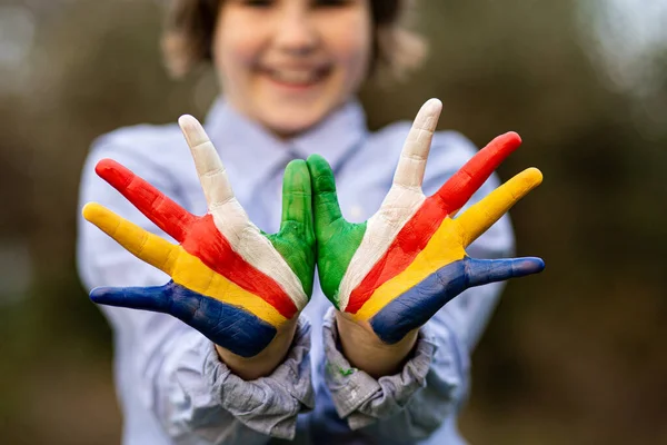 Concept Liberté Seychelles. Enfant mignon formant un geste d'oiseau volant avec les mains peintes aux couleurs du drapeau des Seychelles — Photo