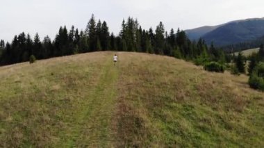 Dağ yolundaki koşucunun hava görüntüsü. Dağ yolunda koşan sporcu..
