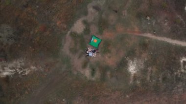 Genç ailenin genel görünüşü çadırın yanındaki battaniyeye uzanıyor ve birlikte kamp tatilinin tadını çıkarıyor.