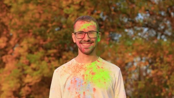 Радостный бородатый мужчина в очках в отличном настроении в цвета холи на фестивале — стоковое видео